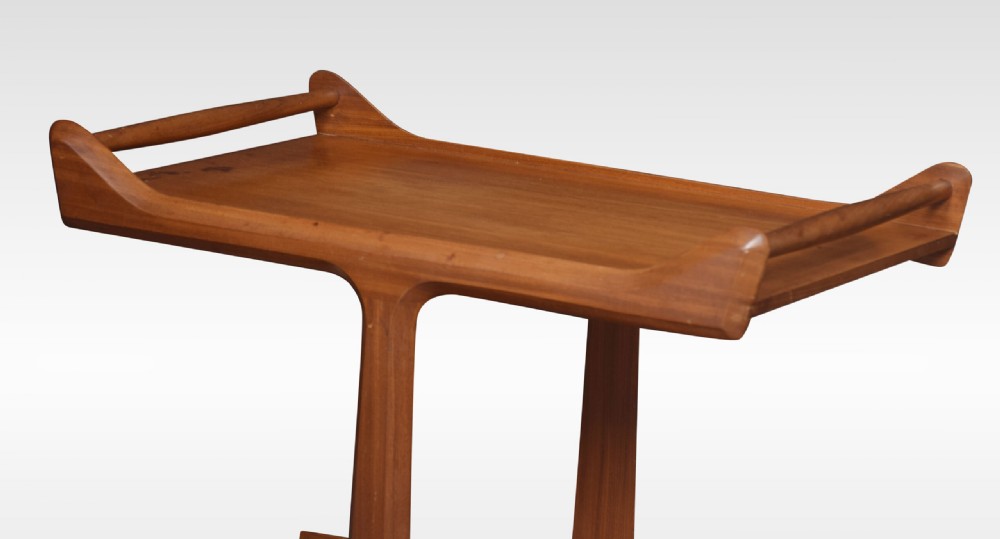 A mid-century modern two-tier walnut drinks trolley with sculpted handles and brass castors. View V