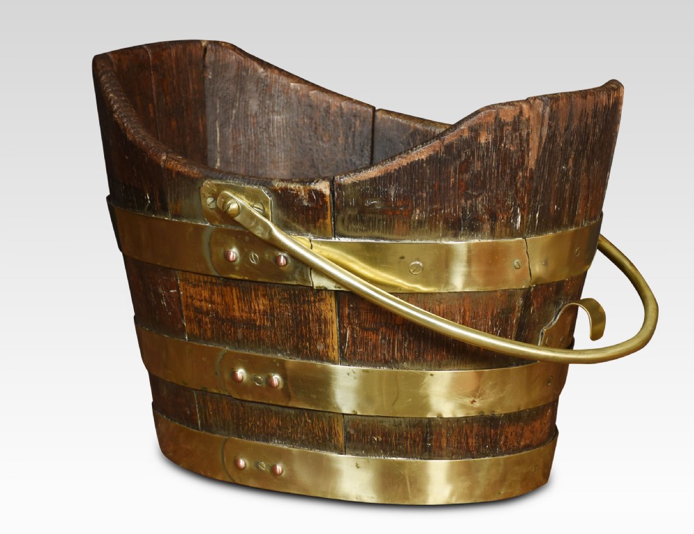 A George III coopered wooden peat bucket featuring a curved scoop rim, brass binding hoops, and a brass swing handle. View II