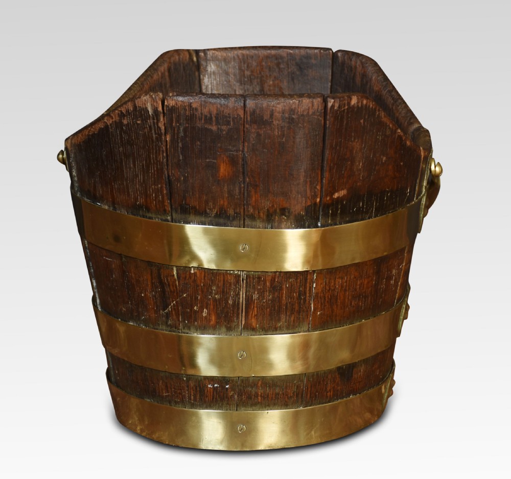 A George III coopered wooden peat bucket featuring a curved scoop rim, brass binding hoops, and a brass swing handle. View III