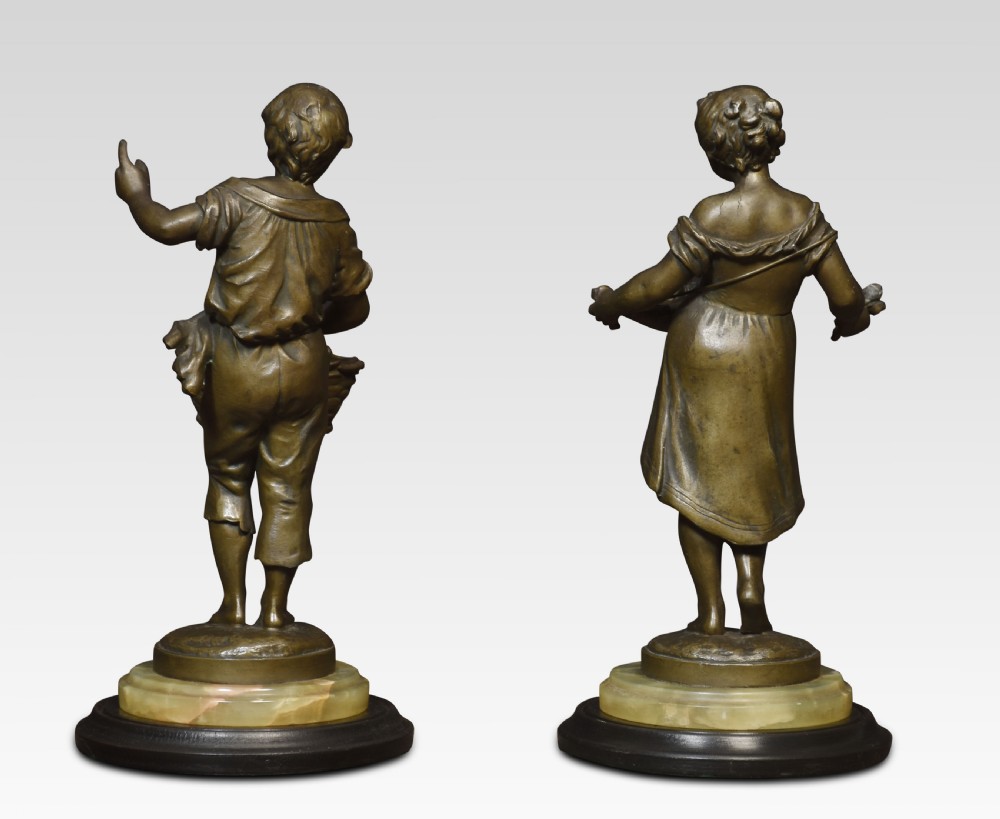 A pair of bronzed French spelter figures depicting a young boy with a basket and a young girl with a tray on alabaster and wooden bases. View IV