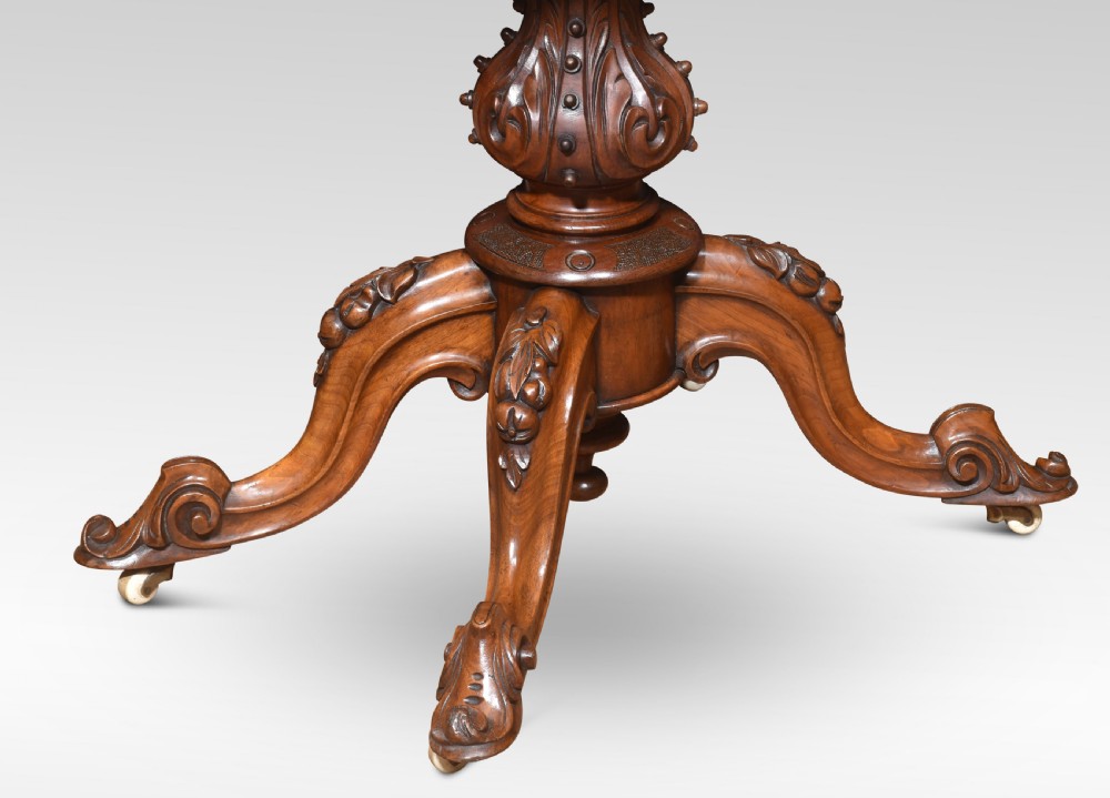 An antique Victorian burr walnut card table featuring a shaped serpentine top lined with green baize, resting on a carved pedestal stem and tripod cabriole legs. View VII
