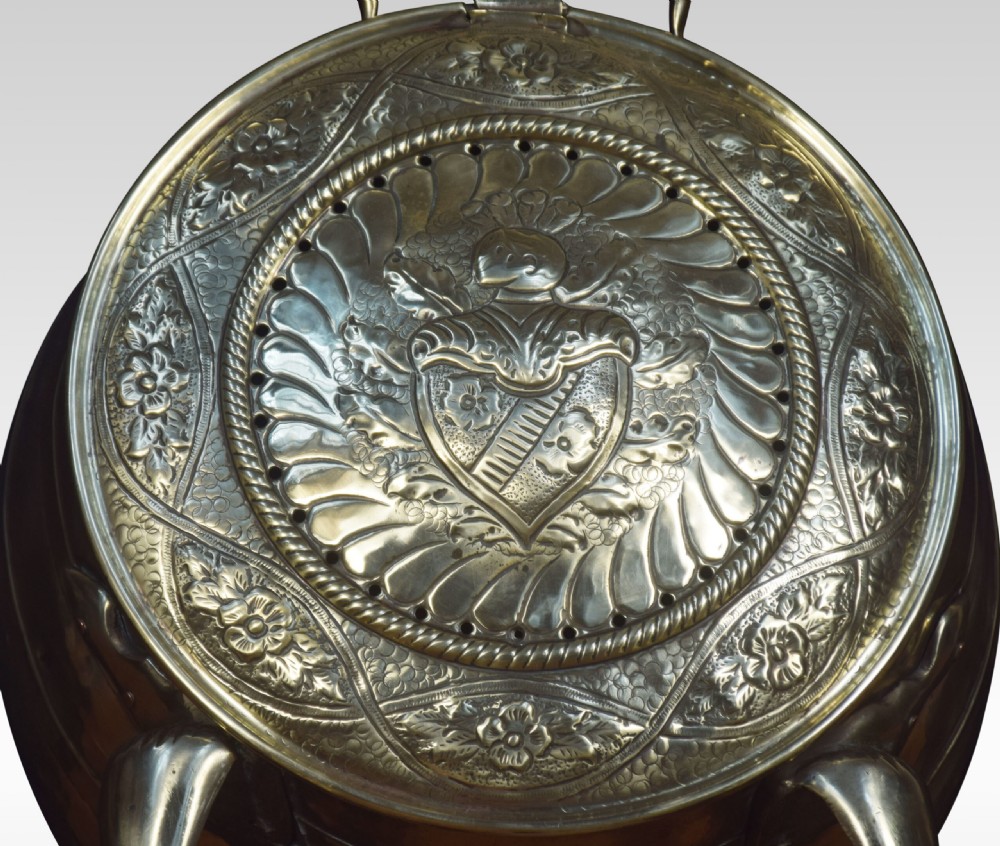 An antique spherical brass coal bin featuring a hinged repousse embossed lid supported by cast metal claw feet. View IV