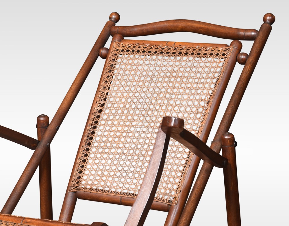 A Victorian walnut folding steamer deck chair with hand-caned backrest and extended footrest. View II