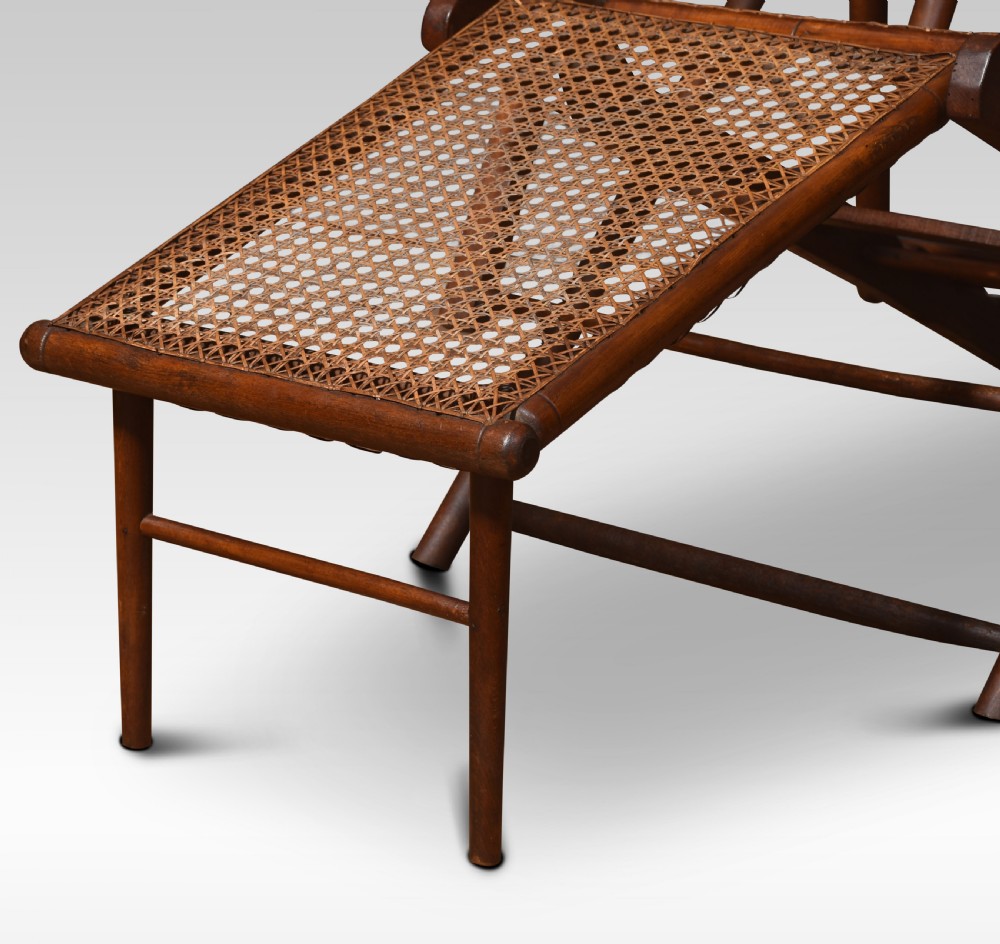 A Victorian walnut folding steamer deck chair with hand-caned backrest and extended footrest. View VI