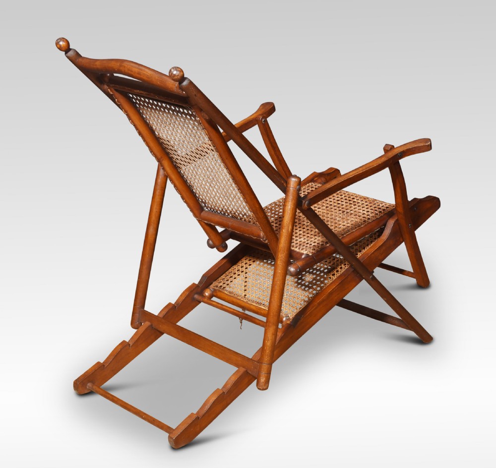 A Victorian walnut folding steamer deck chair with hand-caned backrest and extended footrest. View VIII