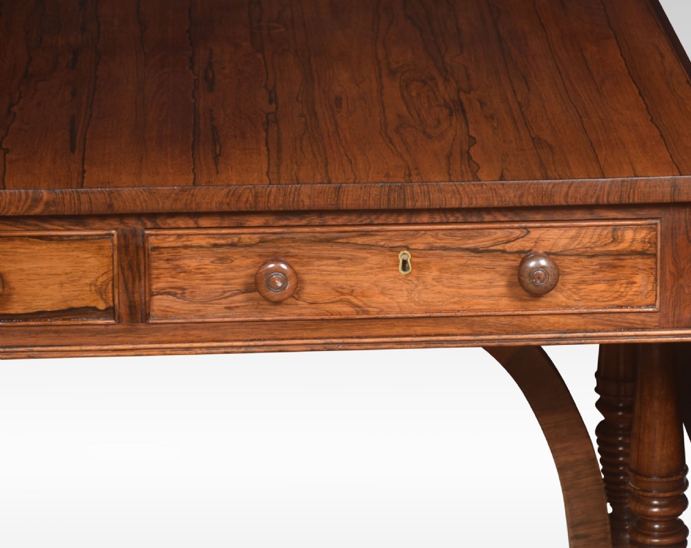 A Regency rosewood sofa table with two drop flaps, two frieze drawers with turned timber knobs, double pillar supports, and splayed legs ending in brass castors. View VIII