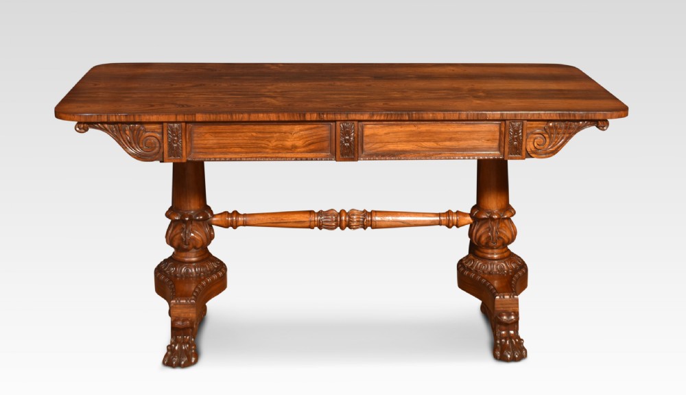 A Regency rosewood library table featuring a rectangular top, twin carved pedestal supports, a turned cross stretcher, and lion paw feet. View III