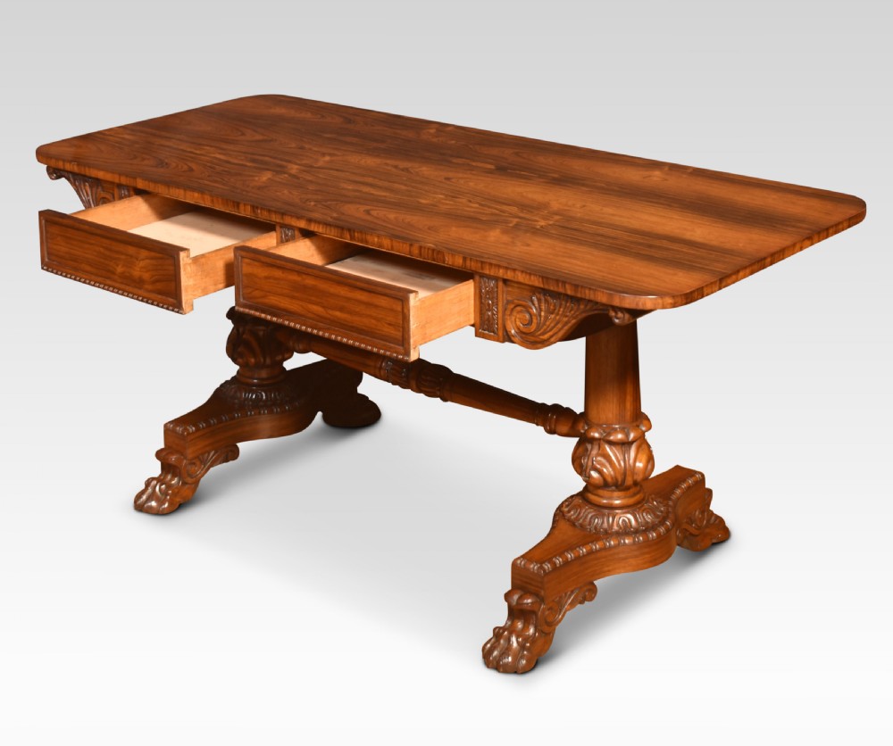 A Regency rosewood library table featuring a rectangular top, twin carved pedestal supports, a turned cross stretcher, and lion paw feet. View IX