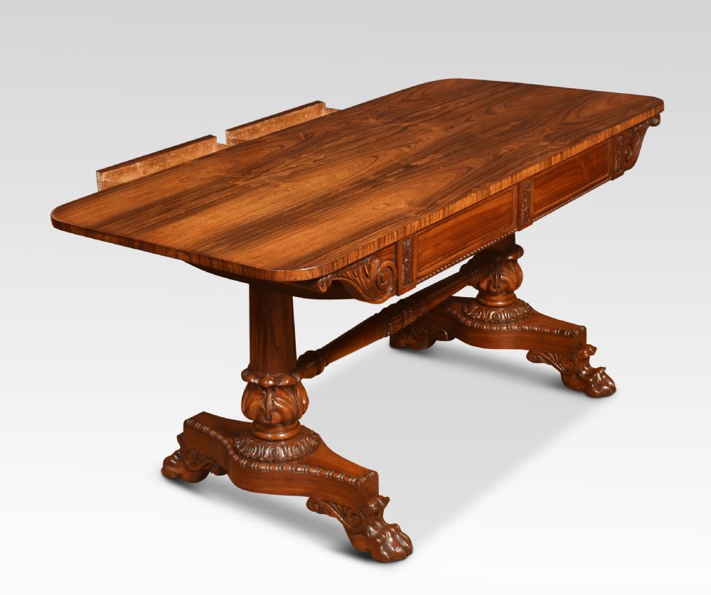 A Regency rosewood library table featuring a rectangular top, twin carved pedestal supports, a turned cross stretcher, and lion paw feet. View XIII