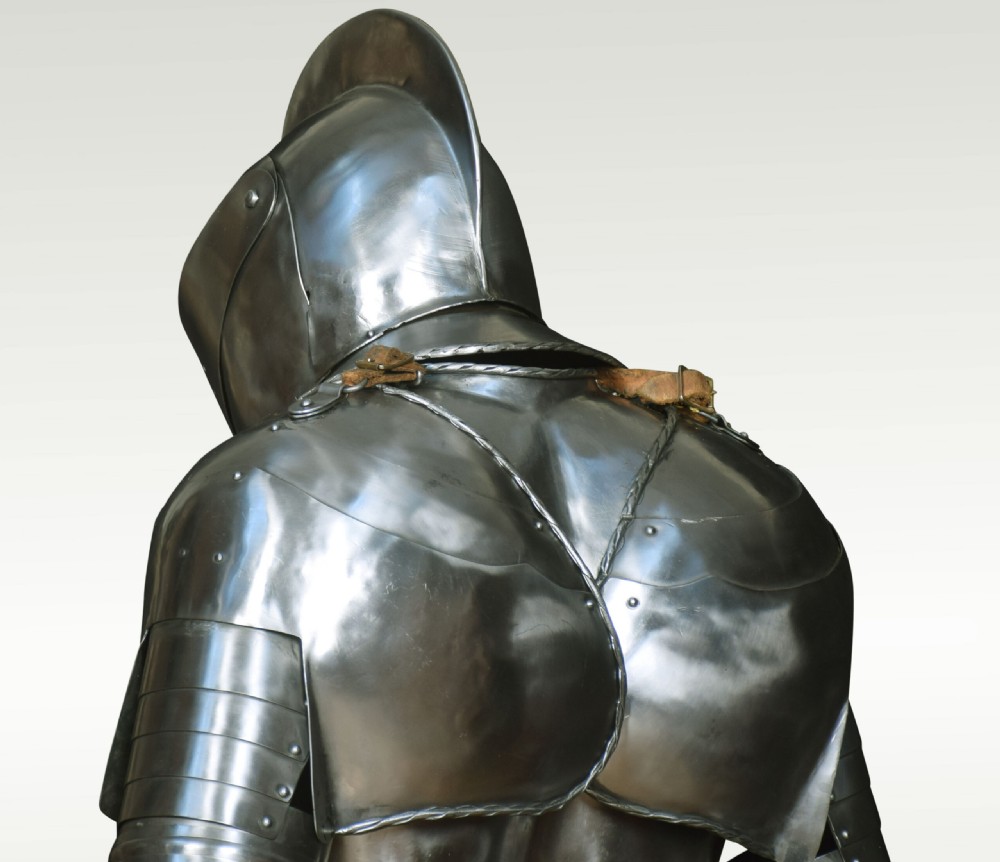 A full suit of polished steel 16th-century style plate armour mounted on a rectangular wooden display plinth. View XIV