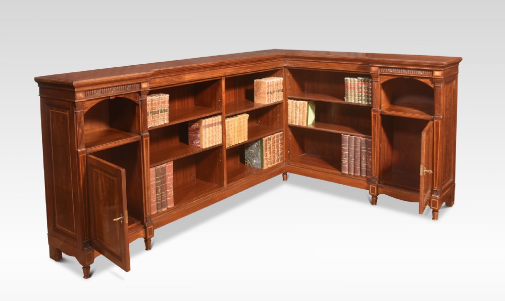 An L-shaped antique mahogany open corner bookcase featuring satinwood inlaid stringing, central open shelves, and flanking side cupboards. View III
