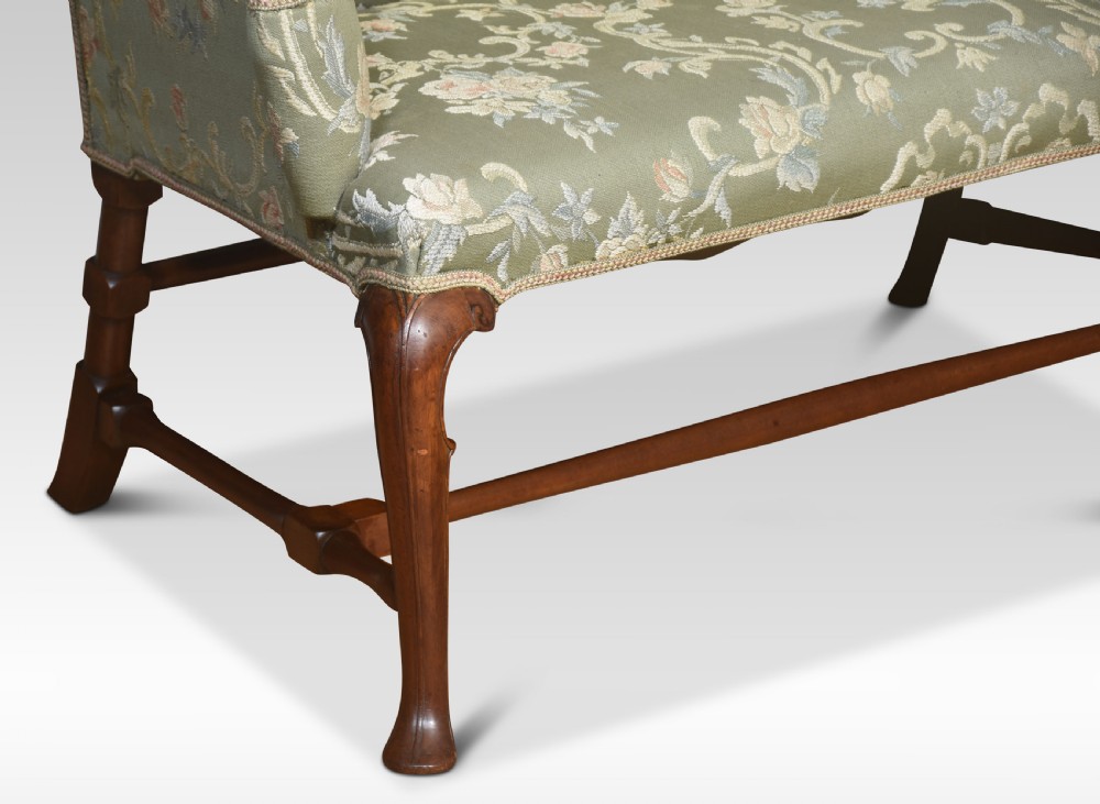 A two-seat Queen Anne style settee upholstered in green floral damask fabric with polished walnut cabriole legs and stretchers. View II