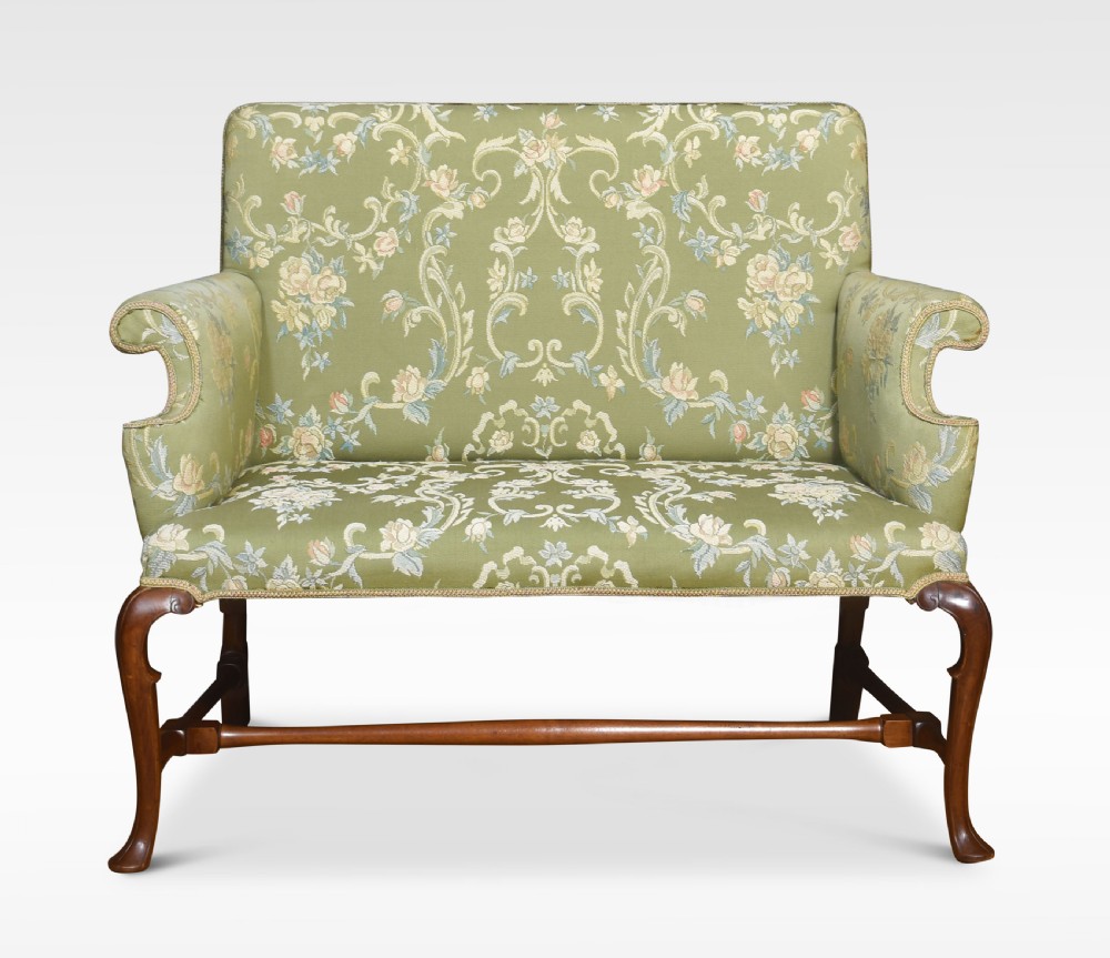 A two-seat Queen Anne style settee upholstered in green floral damask fabric with polished walnut cabriole legs and stretchers. View VI
