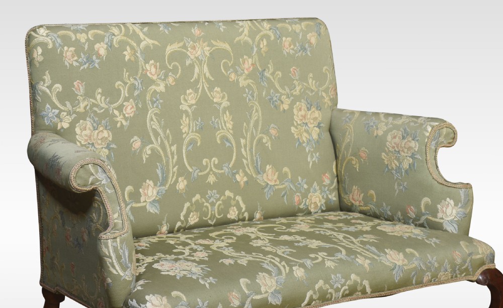A two-seat Queen Anne style settee upholstered in green floral damask fabric with polished walnut cabriole legs and stretchers. View VII