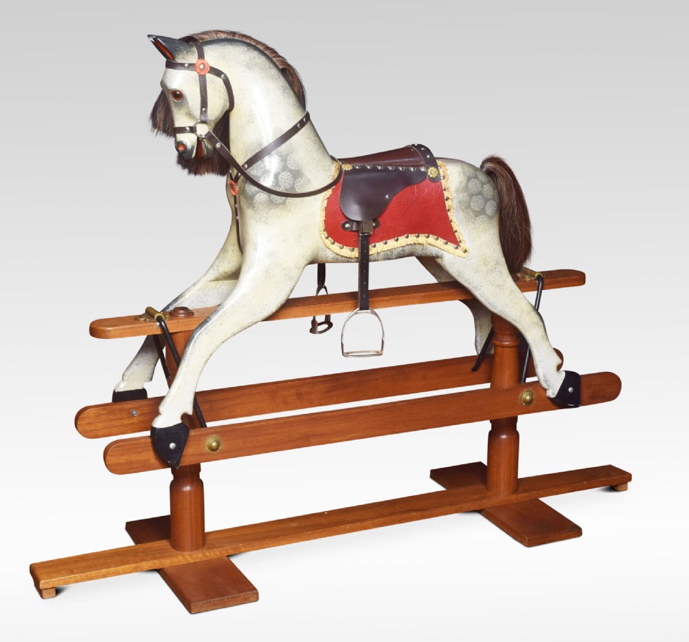 A carved pine rocking horse featuring a dappled grey finish, natural horsehair mane, and leather saddle mounted on a pine safety stand. View II