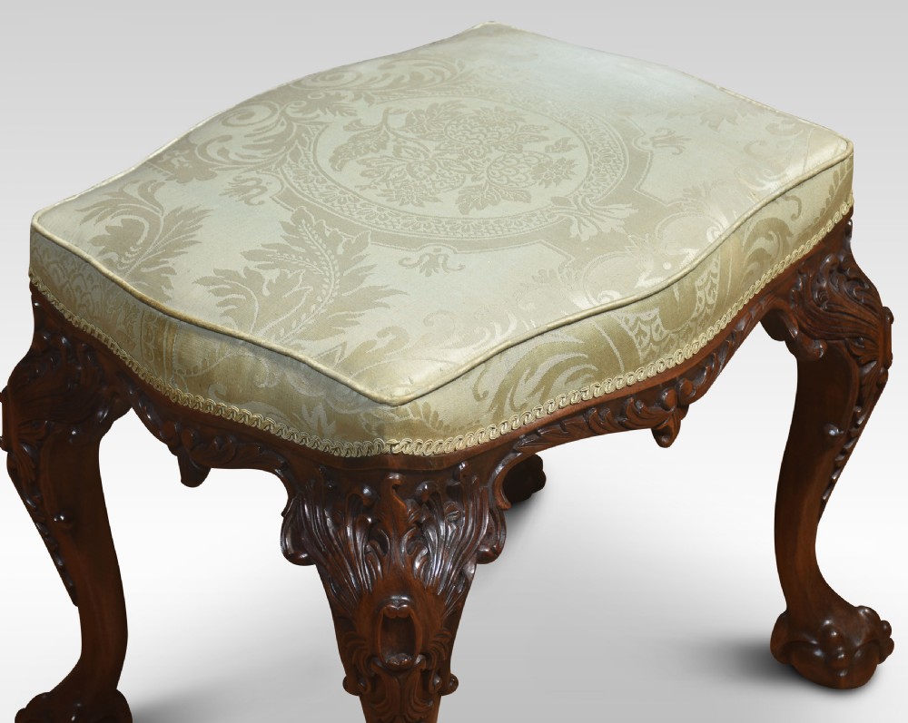 A mahogany Chippendale style stool with carved acanthus leaf cabriole legs, ball-and-claw feet, and a pale green damask upholstered top. View VII