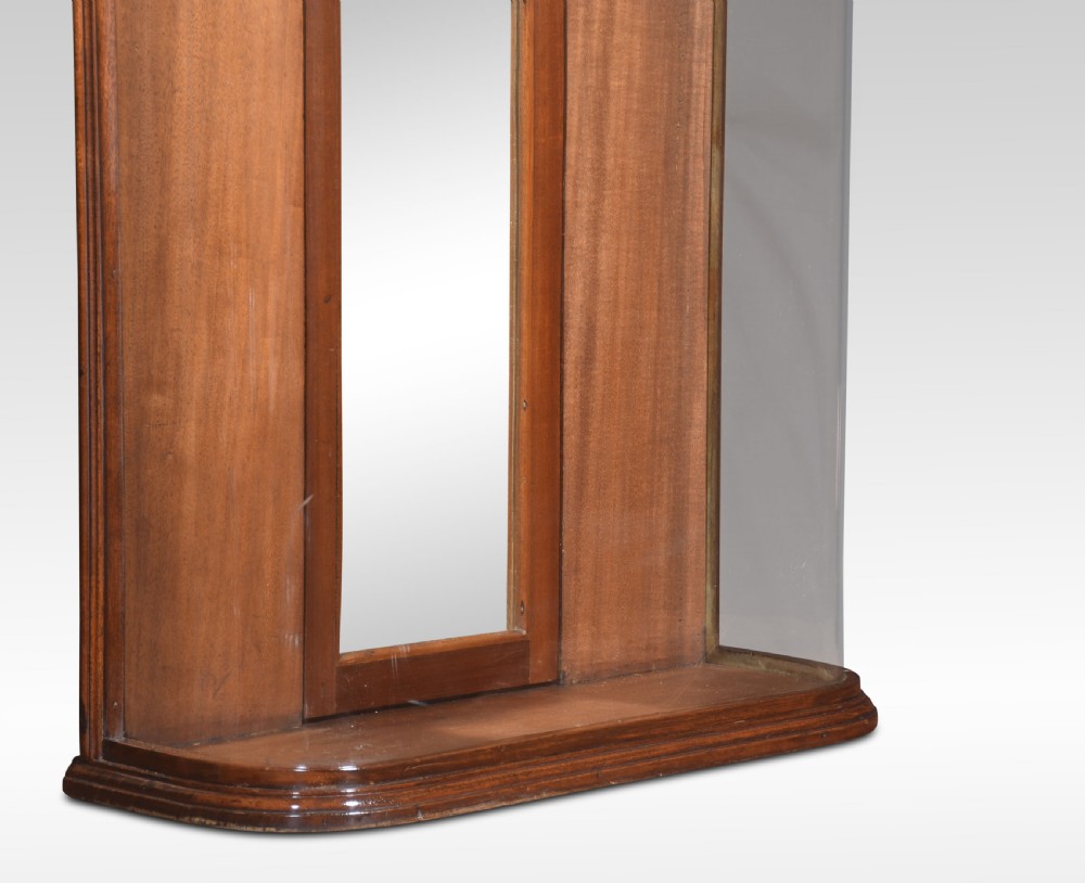 An antique mahogany bow-fronted display cabinet featuring curved glass sides, a mirrored back panel, and a carved cresting pediment at the top. View II