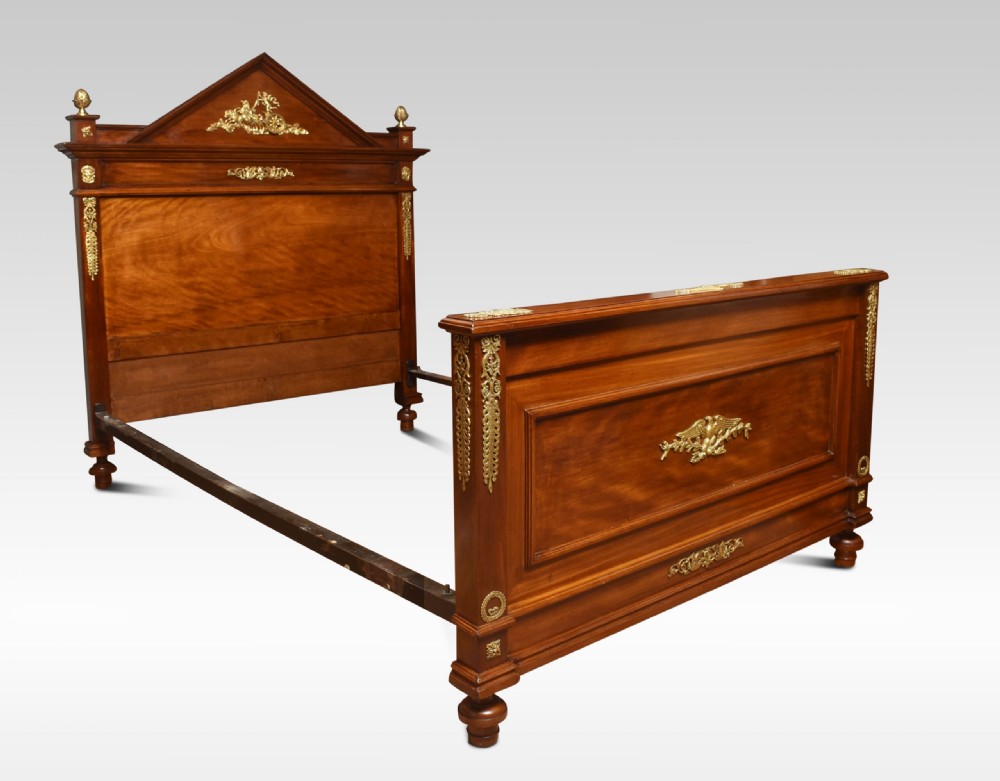 A French Empire style mahogany double bed frame featuring gilt brass mounts, turned feet, and a pediment headboard. View III