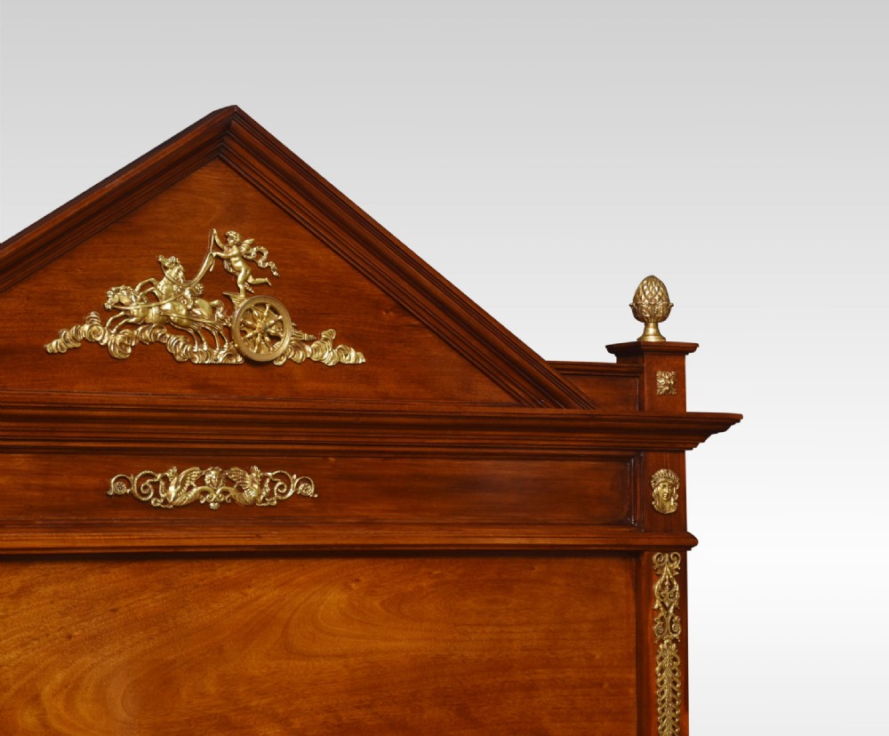 A French Empire style mahogany double bed frame featuring gilt brass mounts, turned feet, and a pediment headboard. View VII