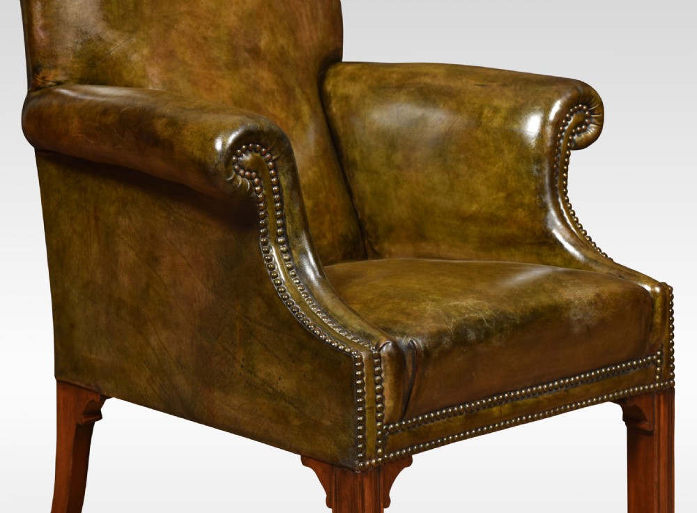 A classic high-backed armchair upholstered in aged brown leather with brass stud detailing and dark mahogany legs. View V