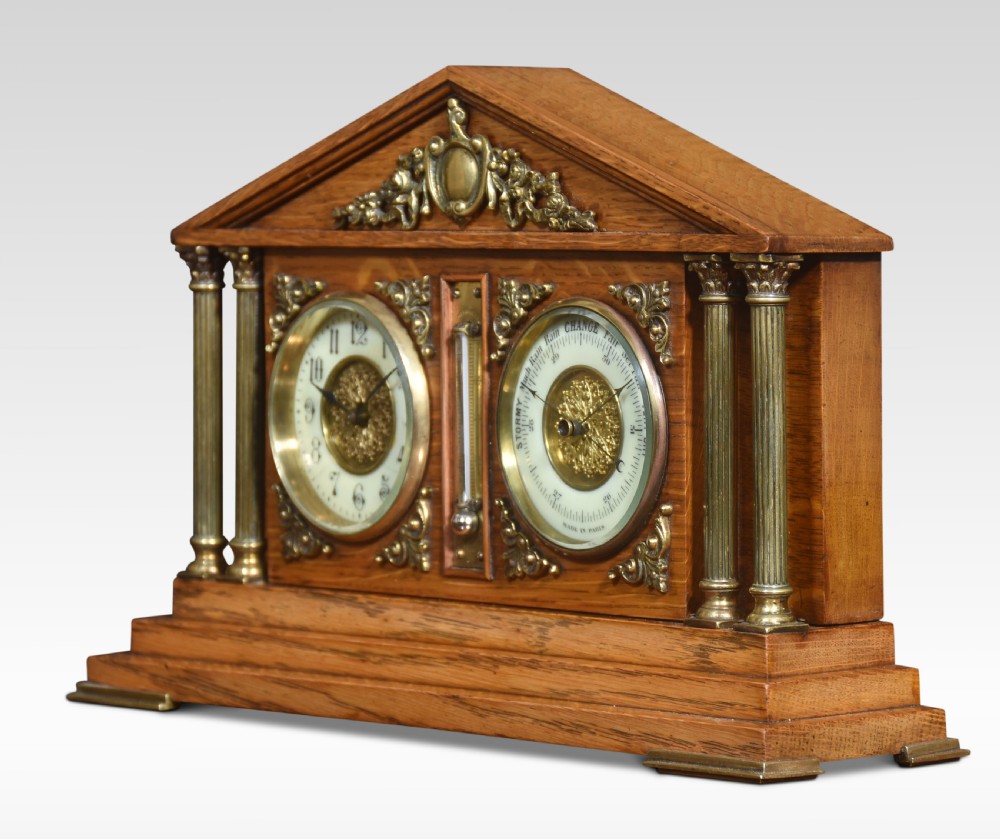 An architectural oak desk clock featuring a triangular pediment top, brass fluted columns, a central thermometer, and twin dials for a clock and barometer. View VI