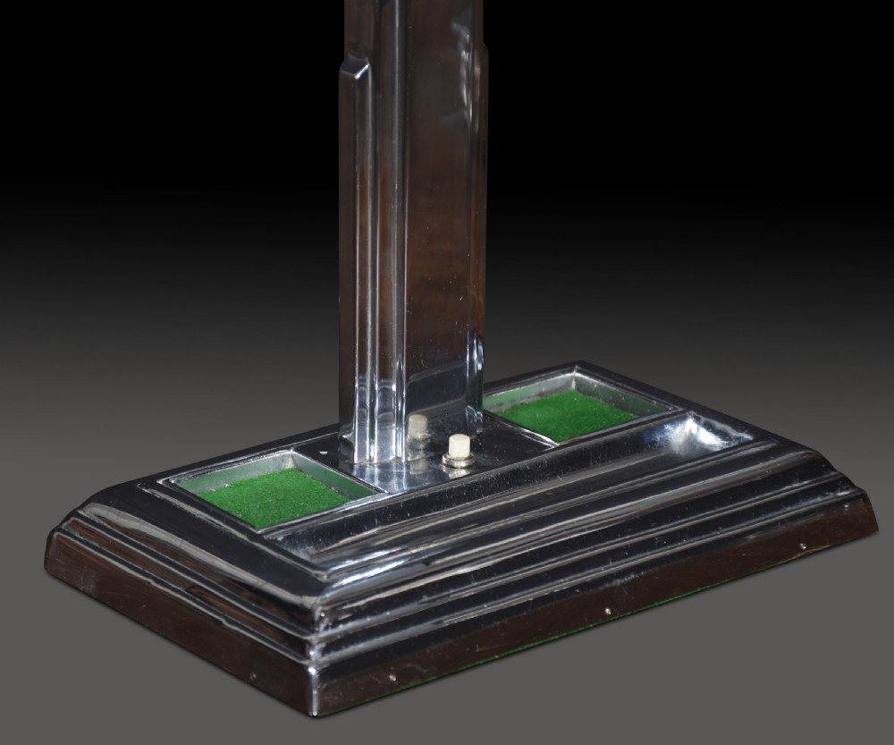 An Art Deco chrome desk lamp featuring a stepped rectangular base with two clear glass inkwells and a geometric column supporting a black rectangular shade. View III