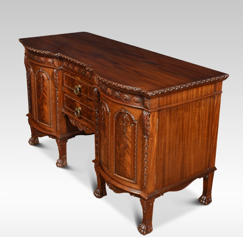 A deep brown mahogany inverted breakfront sideboard featuring carved accents, flame mahogany door panels, two central drawers, and carved claw-and-ball feet. View VIII