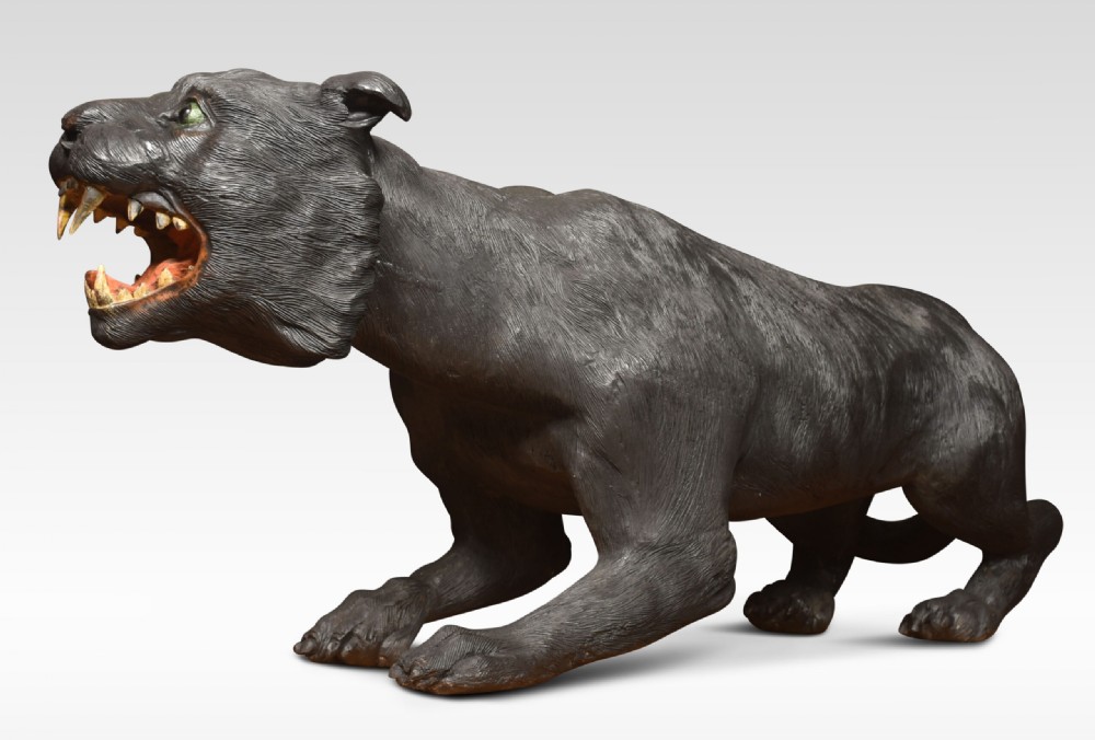 A nineteenth-century hand-carved wooden figure of a snarling black panther with glass eyes and an open painted mouth. View II