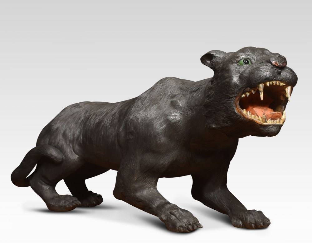 A nineteenth-century hand-carved wooden figure of a snarling black panther with glass eyes and an open painted mouth. View V