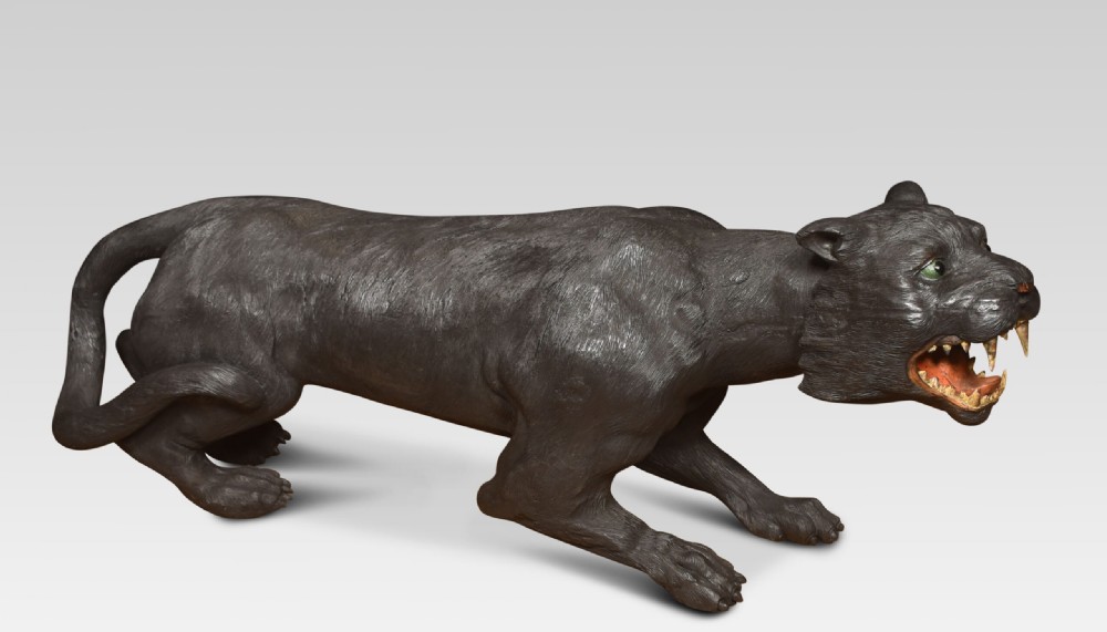 A nineteenth-century hand-carved wooden figure of a snarling black panther with glass eyes and an open painted mouth. View XIII