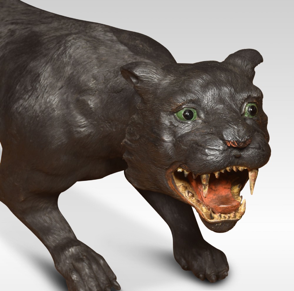A nineteenth-century hand-carved wooden figure of a snarling black panther with glass eyes and an open painted mouth. View XV