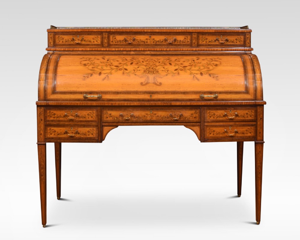 A Sheraton Revival satinwood cylinder bureau featuring detailed floral marquetry inlays, a curved roll-top front, brass gallery, and multiple drawers raised on tapered square legs. View III