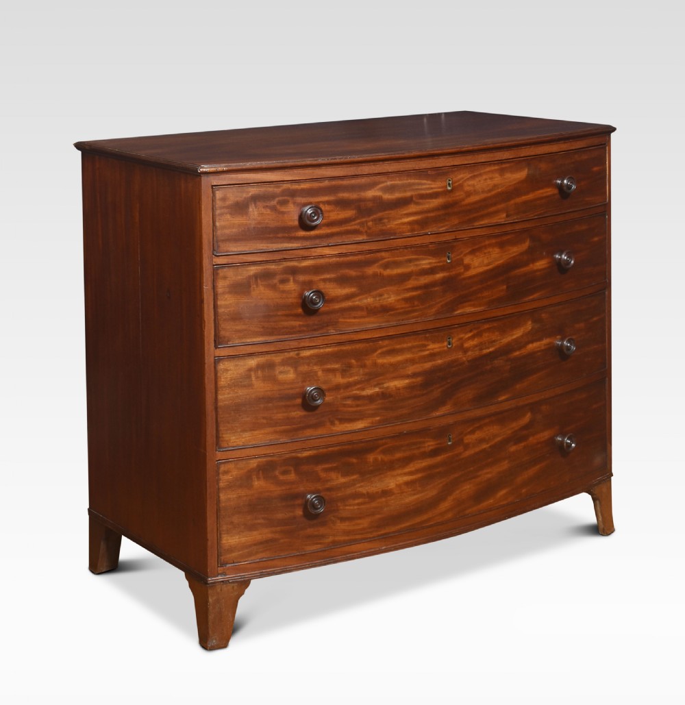 An antique Regency flame mahogany chest featuring four curved bow-front drawers with turned wooden knobs and splayed bracket feet. View II