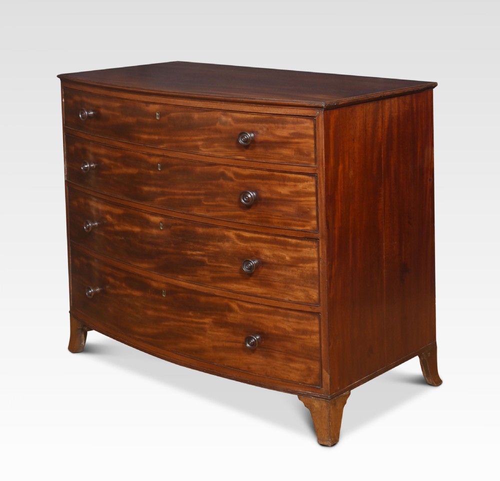 An antique Regency flame mahogany chest featuring four curved bow-front drawers with turned wooden knobs and splayed bracket feet. View V