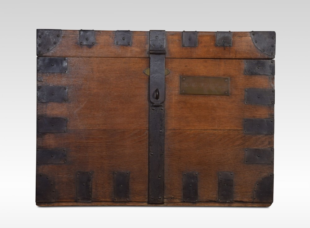 A 19th-century solid oak silver chest reinforced with dark iron straps, corner brackets, and a central latch.