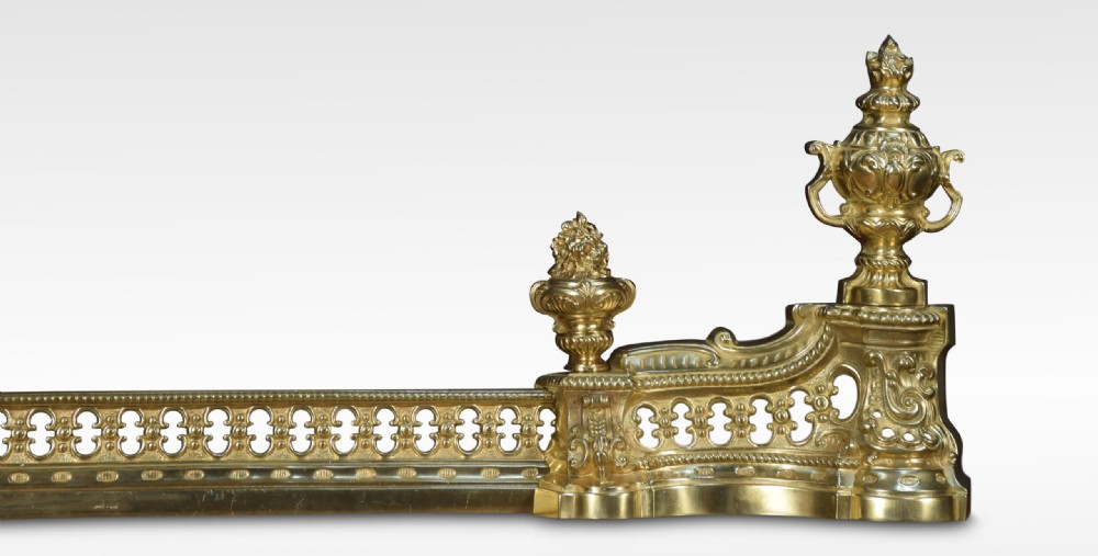 A 19th-century French adjustable gilt-brass fireplace fender featuring twin urn finials and pierced scrollwork. View III
