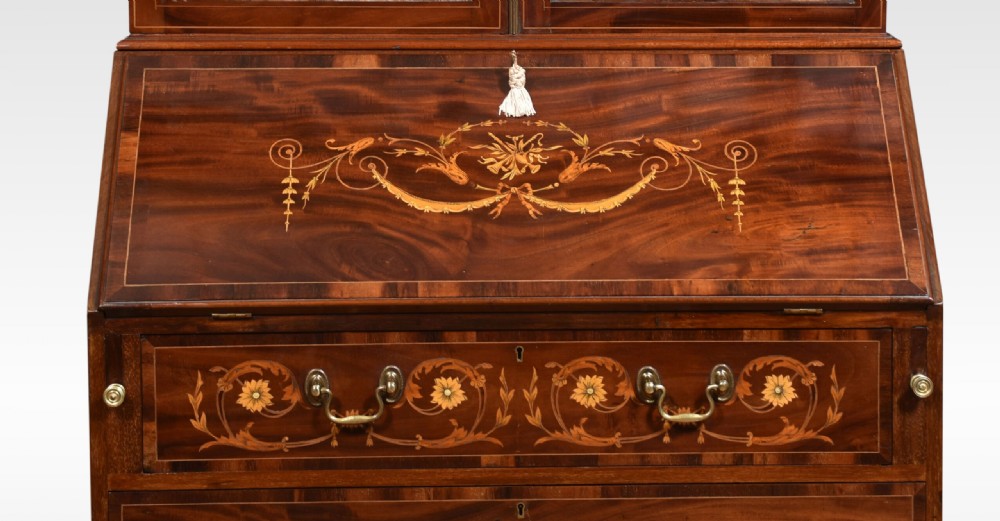 An antique mahogany bureau bookcase featuring a swan-neck pediment, glazed cabinet doors, a drop-down writing desk, and intricate floral marquetry inlay across the lower drawers. View III