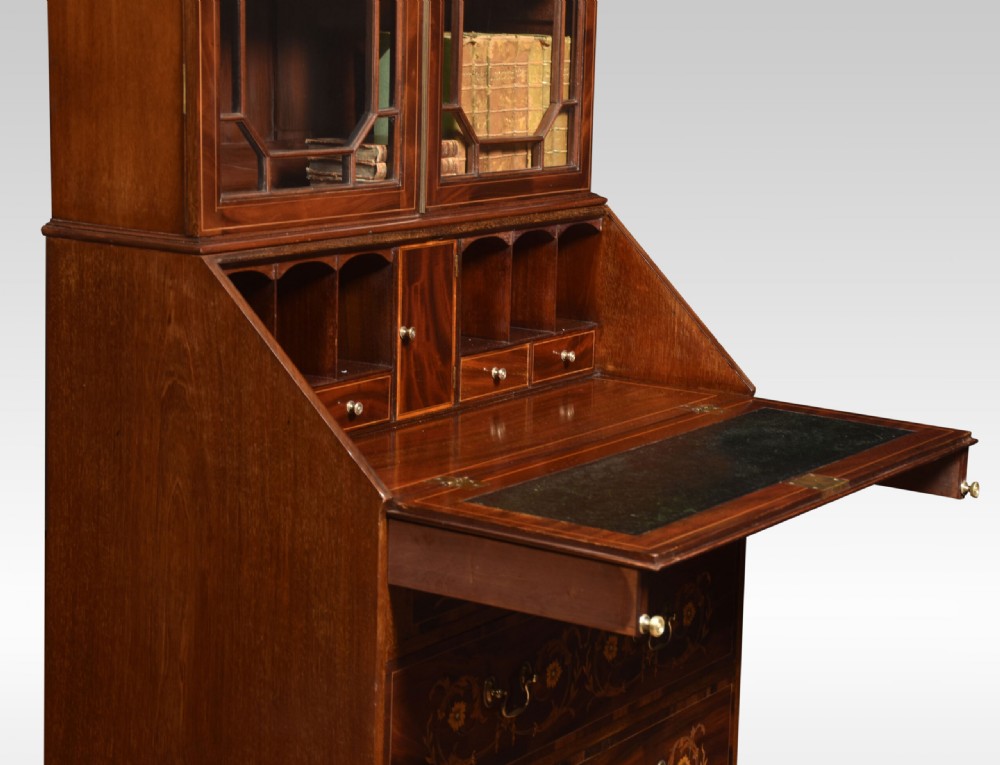 An antique mahogany bureau bookcase featuring a swan-neck pediment, glazed cabinet doors, a drop-down writing desk, and intricate floral marquetry inlay across the lower drawers. View VII