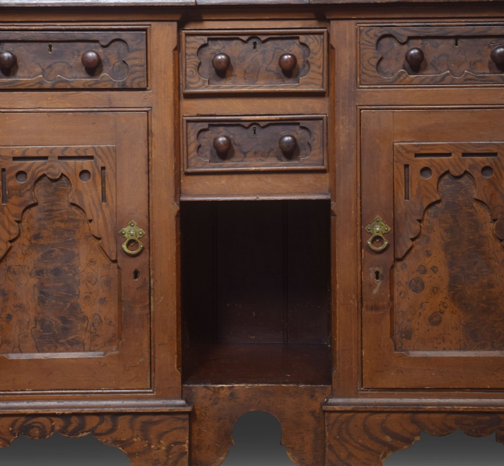 A tall Victorian pine kitchen dresser featuring a faux-grained brown scumbled finish, three glazed upper doors with gothic arched tracery, a blue painted interior, and a lower cupboard base. View VI
