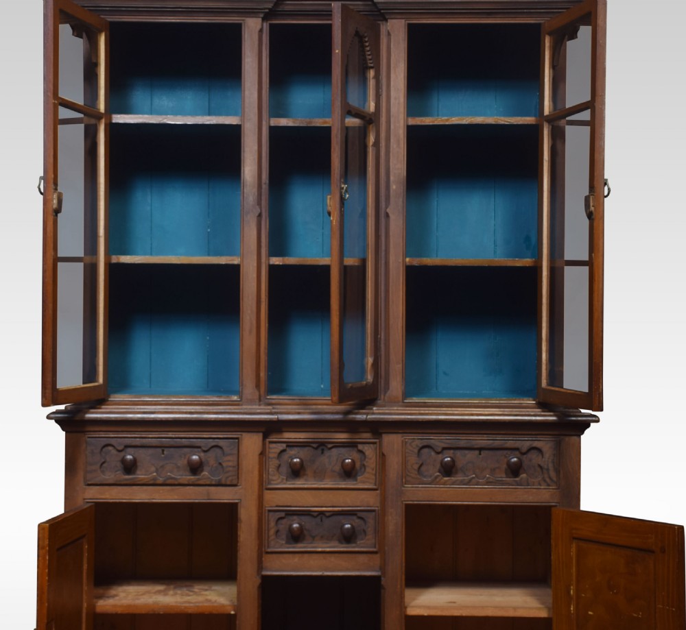 A tall Victorian pine kitchen dresser featuring a faux-grained brown scumbled finish, three glazed upper doors with gothic arched tracery, a blue painted interior, and a lower cupboard base. View VII
