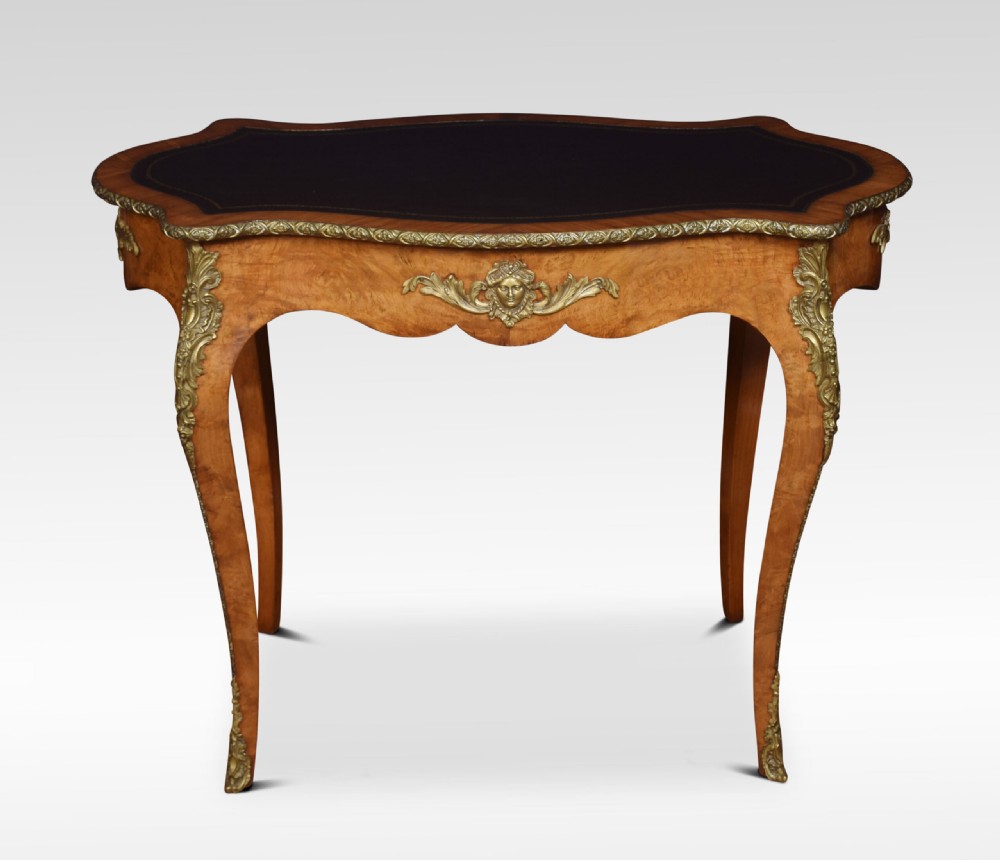 A 19th-century French Rococo style burr walnut writing table with cabriole legs, gilt-bronze mounts, and a dark leather inset top. View VII