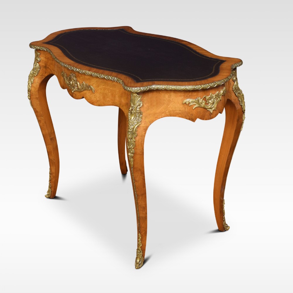 A 19th-century French Rococo style burr walnut writing table with cabriole legs, gilt-bronze mounts, and a dark leather inset top. View IX