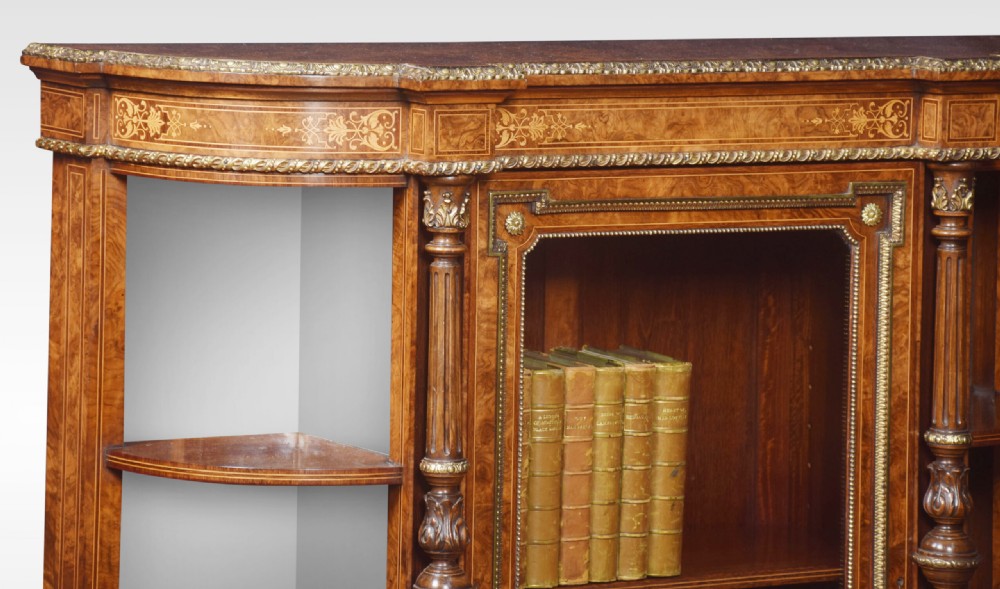 A nineteenth-century figured walnut credenza with a glazed central door, open mirrored side shelves, floral marquetry inlay, and gilt-bronze mounts. View V
