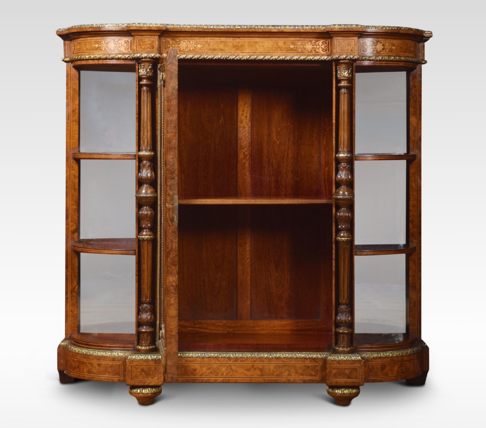 A nineteenth-century figured walnut credenza with a glazed central door, open mirrored side shelves, floral marquetry inlay, and gilt-bronze mounts. View VII