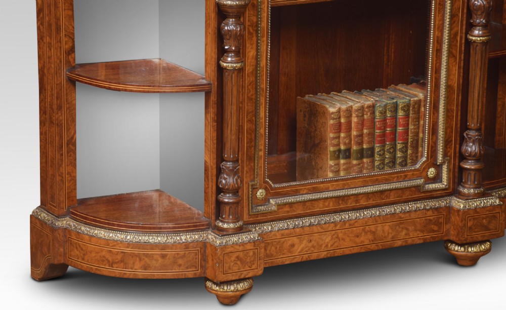 A nineteenth-century figured walnut credenza with a glazed central door, open mirrored side shelves, floral marquetry inlay, and gilt-bronze mounts. View IX