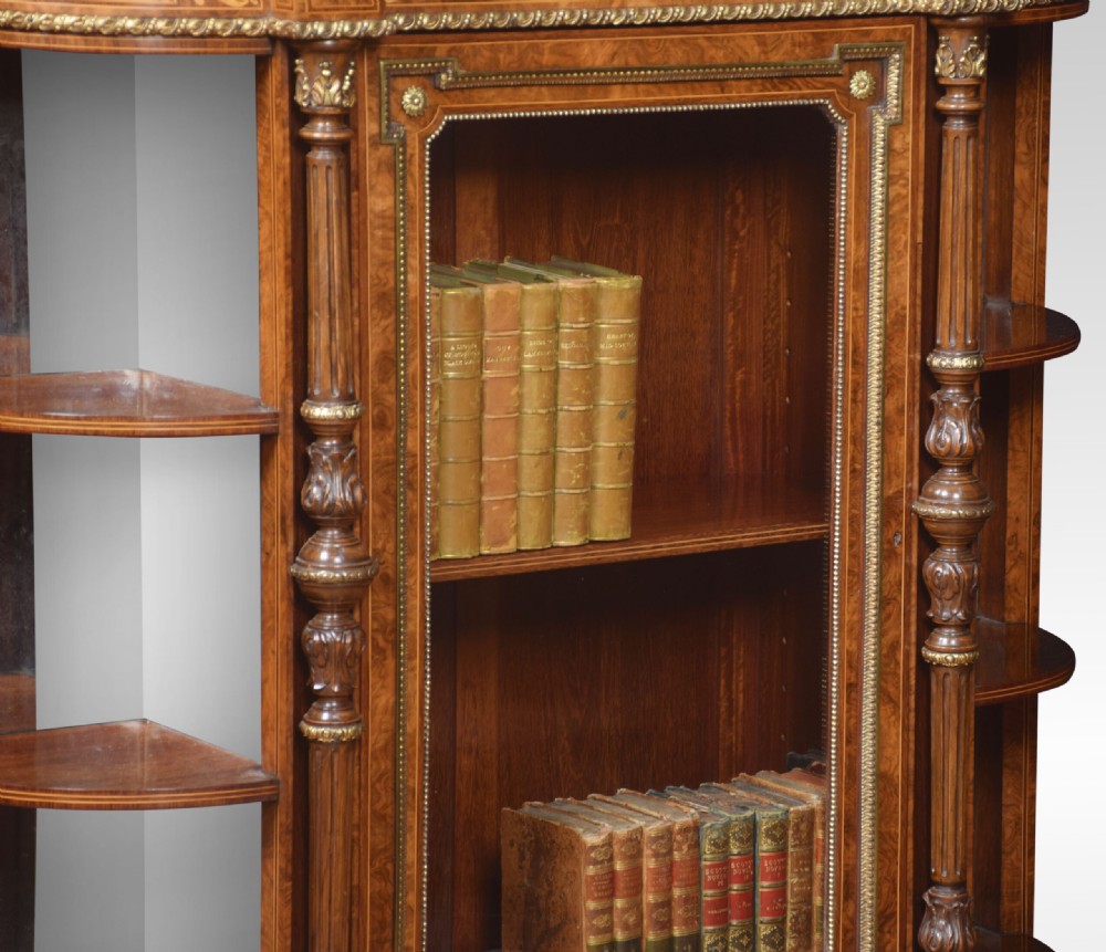 A nineteenth-century figured walnut credenza with a glazed central door, open mirrored side shelves, floral marquetry inlay, and gilt-bronze mounts. View X