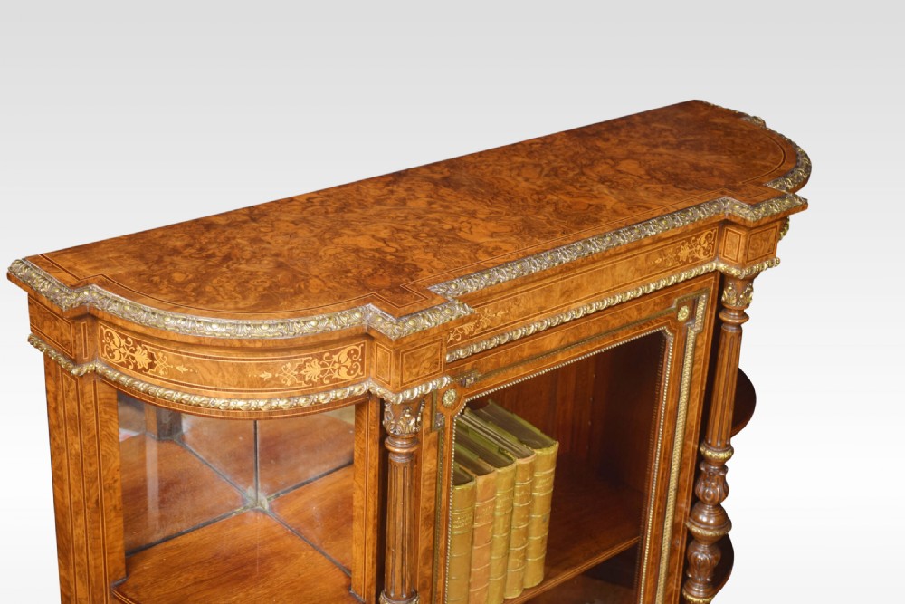 A nineteenth-century figured walnut credenza with a glazed central door, open mirrored side shelves, floral marquetry inlay, and gilt-bronze mounts. View XII