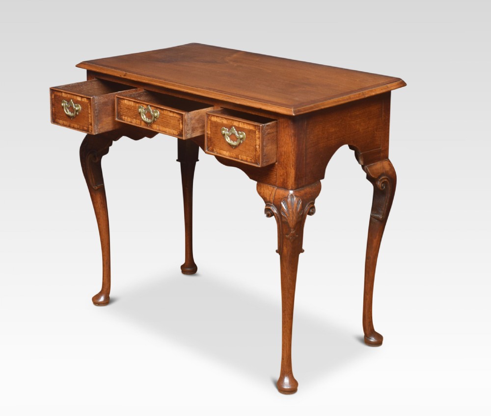 An eighteenth-century Queen Anne walnut lowboy table with three drawers, brass drop handles, a shaped apron, and cabriole legs ending in pad feet. View III