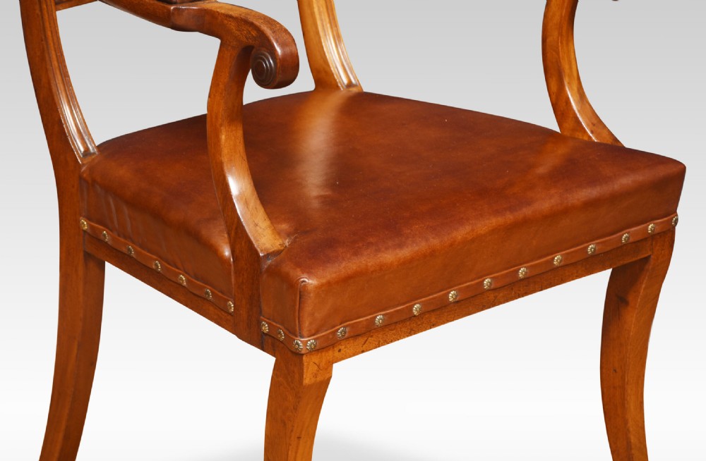 A set of eight Regency mahogany dining chairs featuring brown leather seats with brass stud detail, tablet top rails, and sabre legs. View III