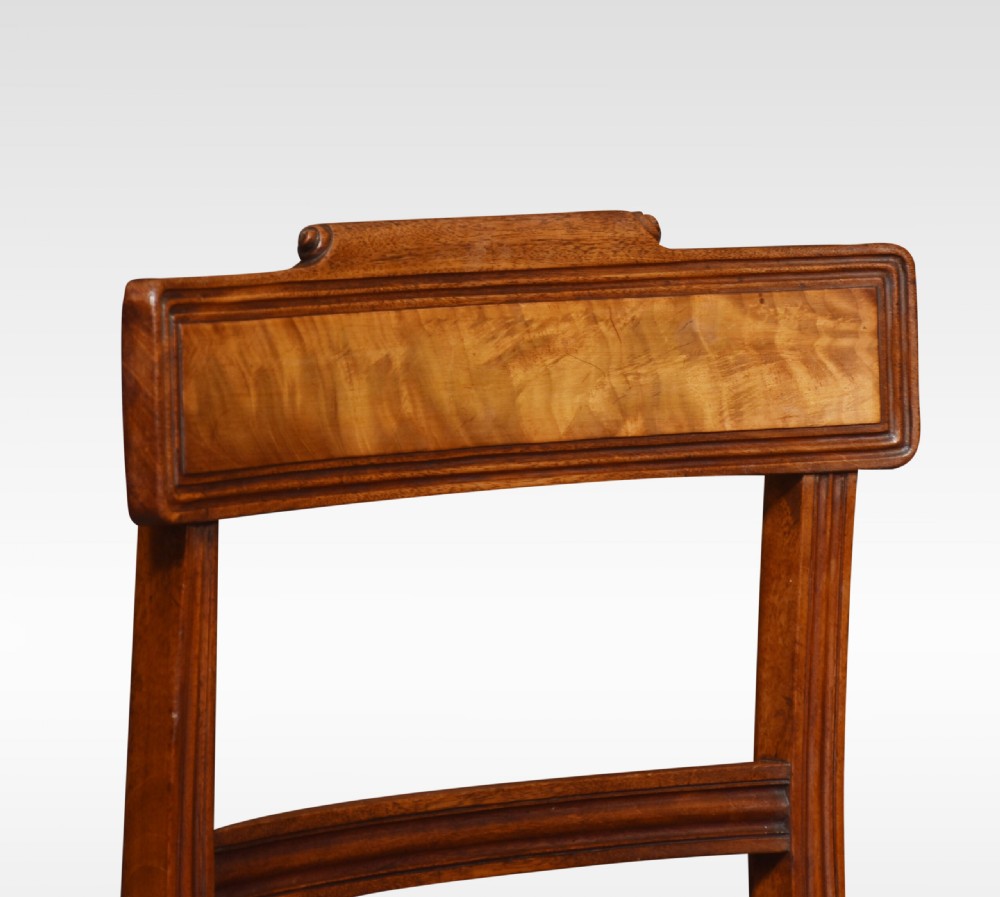 A set of eight Regency mahogany dining chairs featuring brown leather seats with brass stud detail, tablet top rails, and sabre legs. View VIII